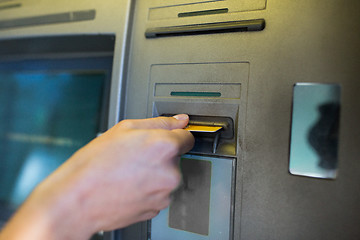 Image showing close up of hand inserting card to atm machine