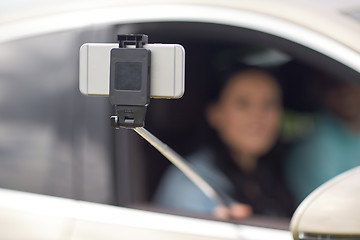 Image showing couple driving in car and taking smartphone selfie