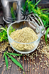 Image showing Flour hemp in glass cup with leaf on dark board