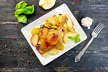 Image showing Duck leg with apple and potatoes on board top