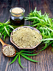 Image showing Flour hemp in bowl with oil and spoon on dark board