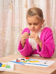 Image showing Seven-year girl with enthusiasm podklku sculpts from clay