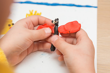 Image showing Child sculpts from clay butterfly, close-up