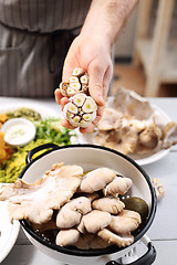 Image showing A chef holding a head of fresh garlic. 