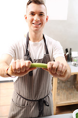 Image showing The cook holds in his hand a vegetable.