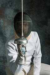 Image showing The man wearing fencing suit with sword against gray