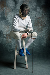 Image showing The man wearing fencing suit with sword against gray