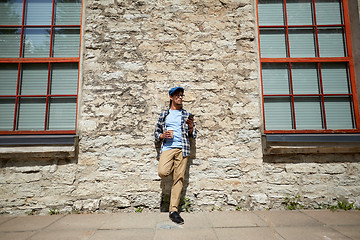 Image showing man with smartphone drinking coffee on city street