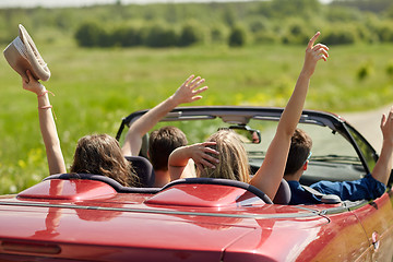 Image showing happy friends driving in cabriolet car at country