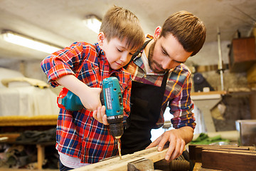 Image showing father and son with drill working at workshop