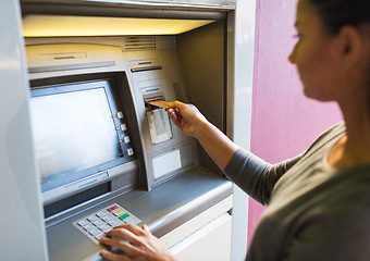 Image showing close up of woman inserting card to atm machine