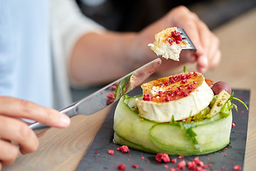 Image showing woman eating goat cheese salad at restaurant