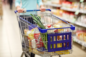 Image showing woman with food in shopping cart at supermarket