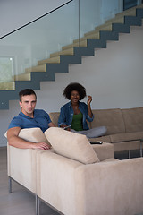 Image showing multiethnic couple relaxing at  home with tablet computers