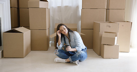 Image showing Tired young woman taking a break from moving house