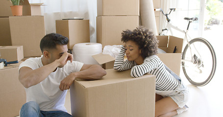 Image showing Exhausted couple taking a break from packing