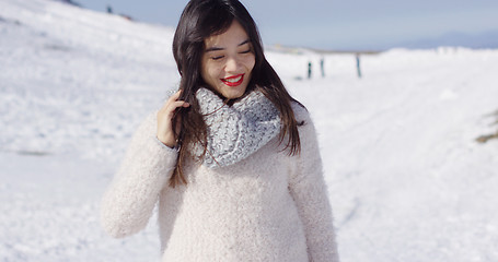 Image showing Smiling asian girl in woolen sweater relaxing