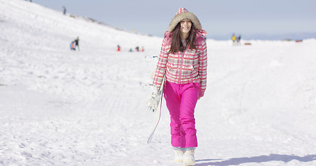 Image showing Young woman walking with snowboard