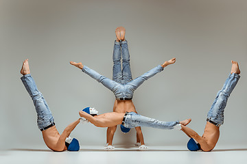 Image showing The group of gymnastic acrobatic caucasian men on balance pose