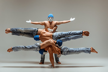 Image showing The group of gymnastic acrobatic caucasian men on balance pose