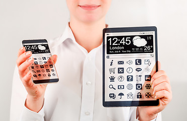 Image showing Smartphone and tablet with transparent screen in human hands.