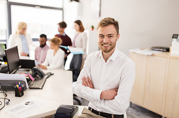 Image showing happy young man over creative team in office