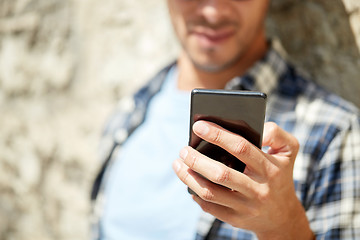 Image showing man with smartphone texting message outdoors