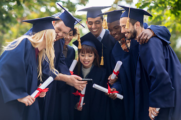 Image showing students or bachelors with diplomas and smartphone