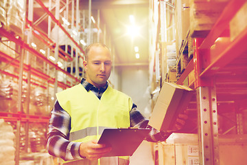 Image showing man with clipboard in safety vest at warehouse