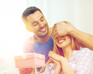 Image showing smiling man surprises his girlfriend with present