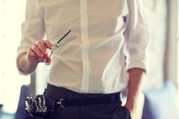 Image showing close up of male stylist with scissors at salon