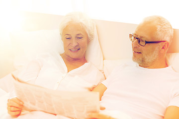 Image showing happy senior couple with newspaper in bed