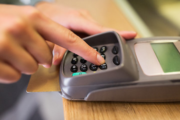 Image showing close up of hand entering code to money terminal