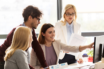 Image showing happy creative team with computer in office