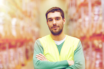 Image showing happy man in reflective safety vest at warehouse