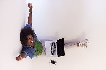 Image showing african american woman sitting on floor with laptop top view