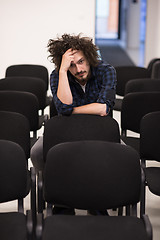 Image showing A student sits alone  in a classroom