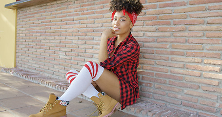 Image showing Thoughtful chic young woman sitting on the ground