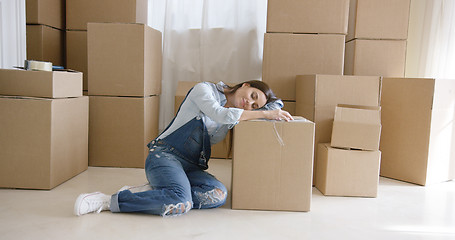 Image showing Tired young woman taking a break from packing