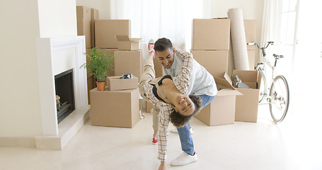 Image showing Mixed race couple dancing in new home