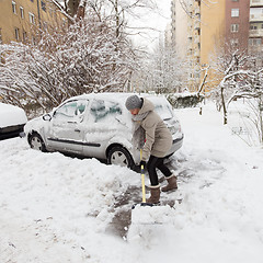 Image showing Independent woman shoveling snow in winter.