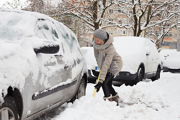 Image showing Independent woman shoveling snow in winter.