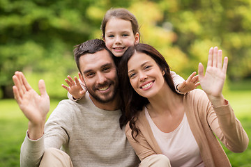 Image showing happy family in summer park waving hands