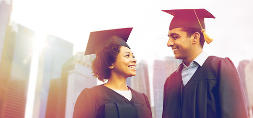 Image showing happy students or bachelors in mortar boards