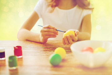 Image showing close up of girl with brush coloring easter eggs