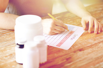 Image showing close up of man with protein jars and diet plan