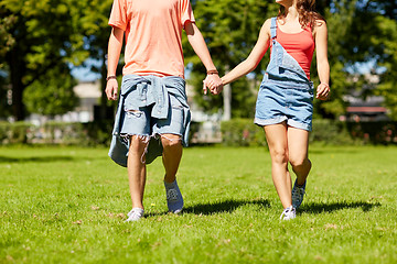 Image showing happy teenage couple walking at summer park