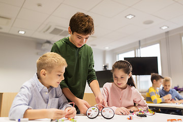 Image showing happy children building robots at robotics school