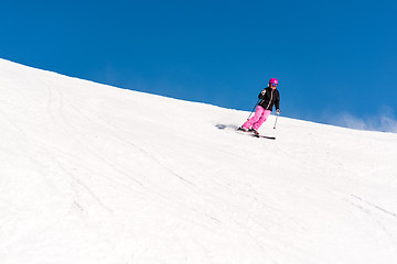 Image showing Female skier in fresh powder snow and blue sky