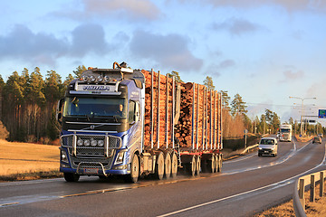 Image showing Blue Volvo FH16 Wood Transport Truck on Highway in Winter 